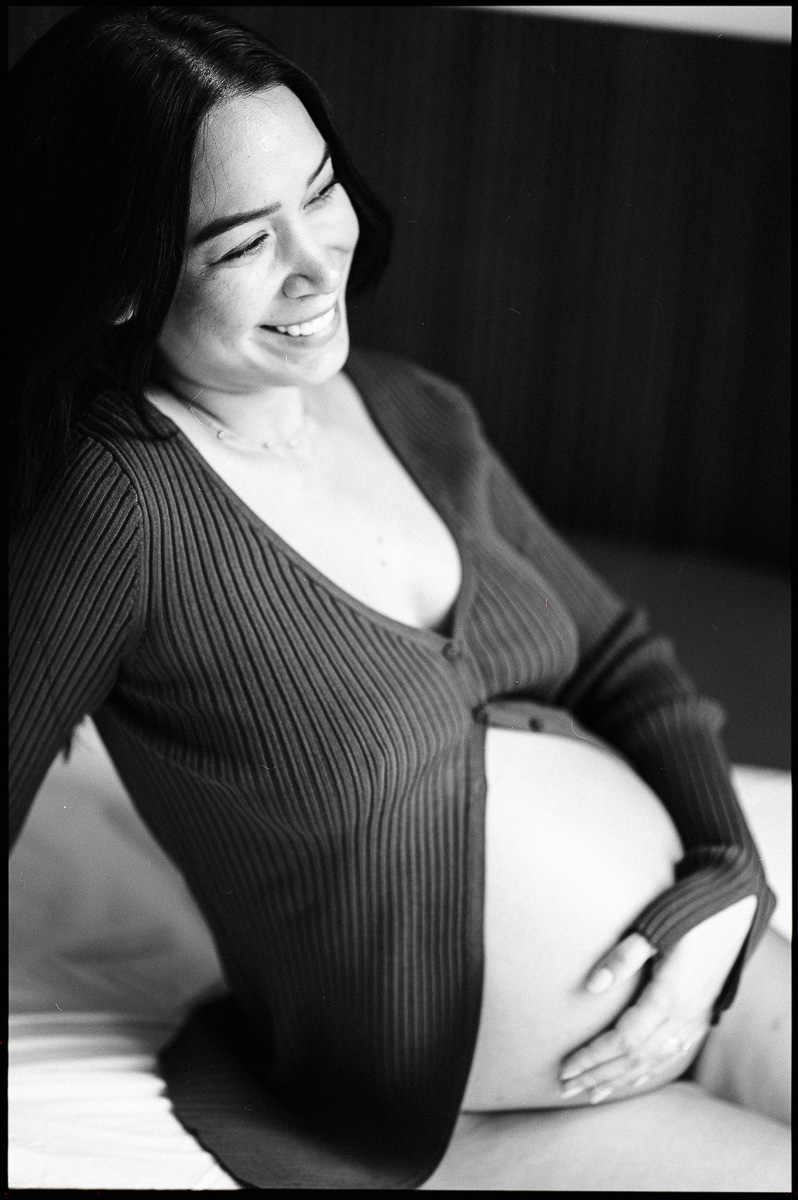 black and white maternity photograph of smiling young woman